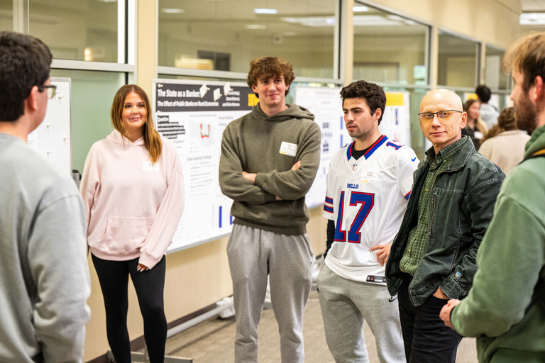 2025 FYS Poster Session presenters and crowd surrounding a poster with title unknown