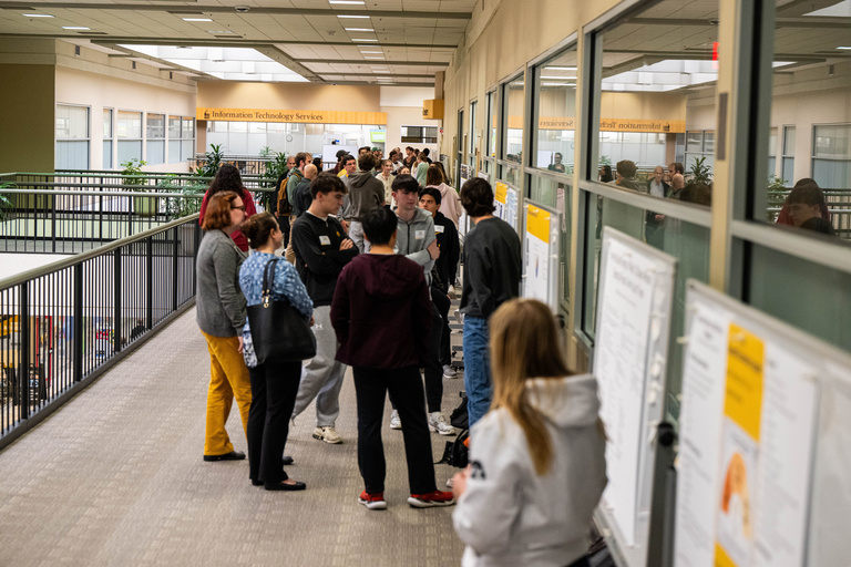 2025 FYS Poster Session crowd of visitors down the hallway of posters