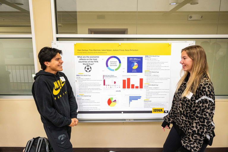 2025 FYS Poster Session two presenters with their poster titled What are the Economic Effects on the Host Countries of the FIFA World Cup