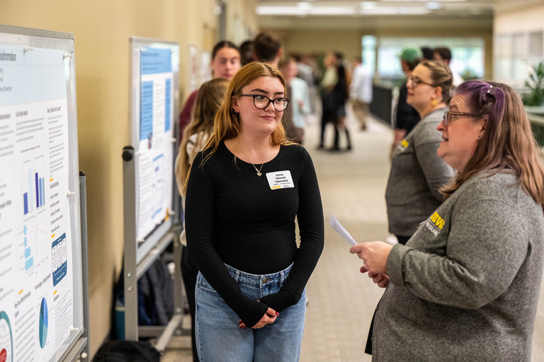2025 FYS Poster Session presenter speaking with staff member