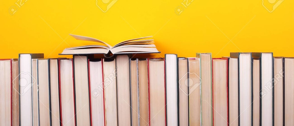 Books setting next to each other on a wooden table