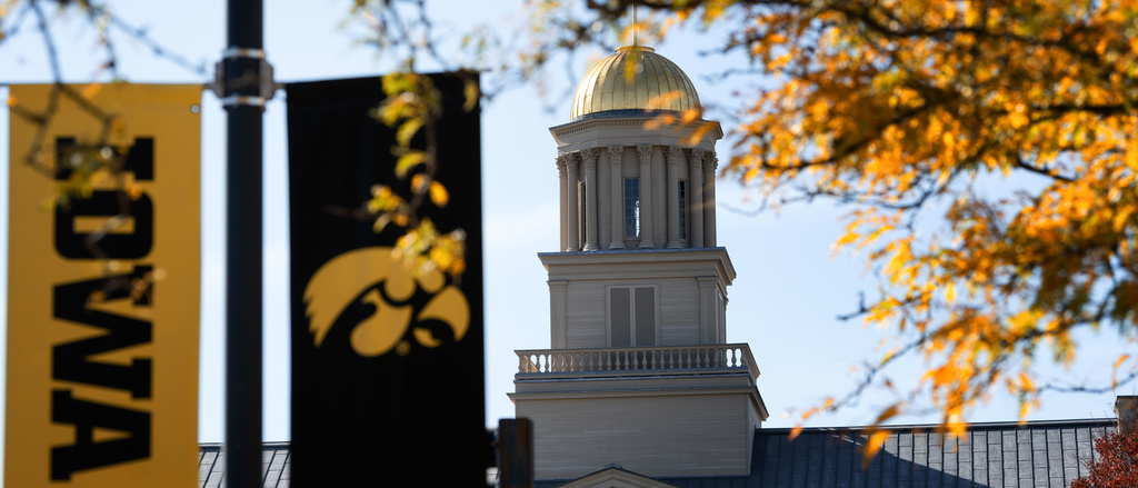 old capitol building in the fall with IOWA banners