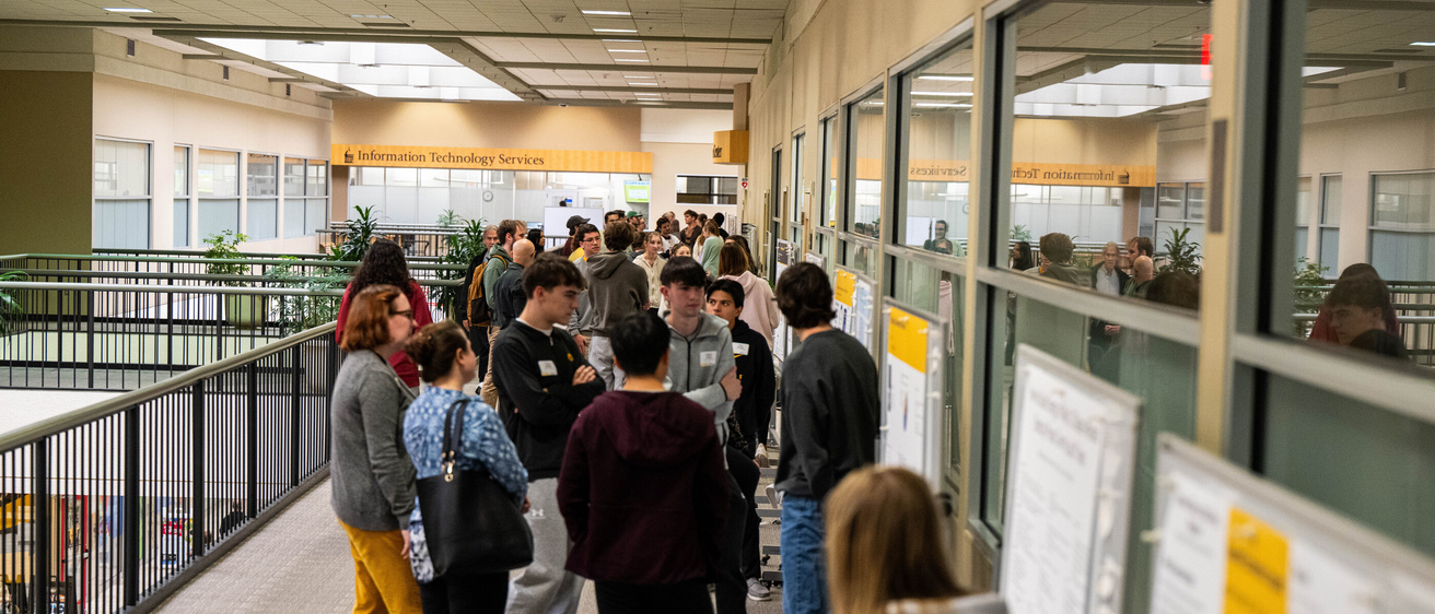 2025 FYS Poster Session crowd of visitors down the hallway of posters