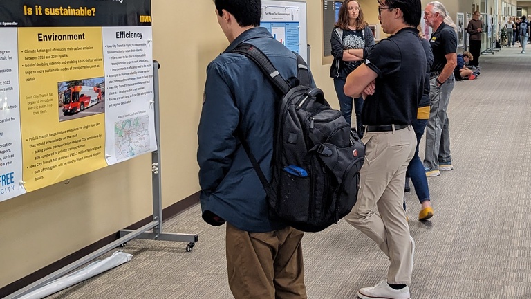 Fall 2023 FYS poster session with students and staff looking at posters
